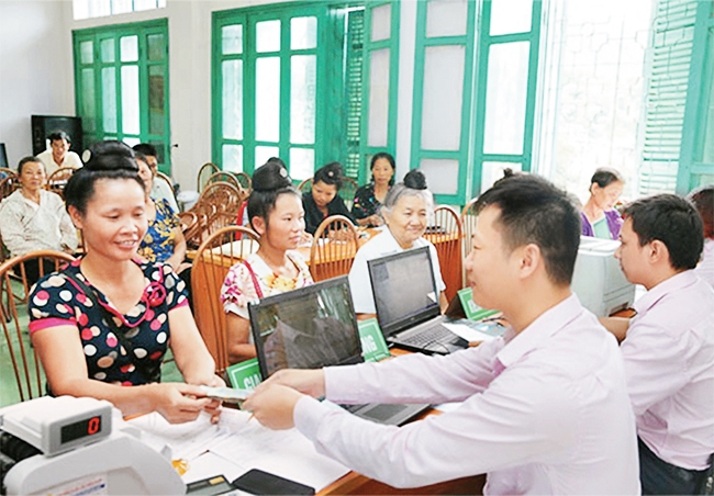 Người dân vay vốn phát triển sản xuất tại Ngân hàng Chính sách xã hội huyện Tuần Giáo (Điện Biên). Ảnh: TRẦN MINH